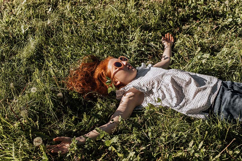 girl enjoying lying in grass for nature healing